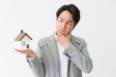 man holding miniature house