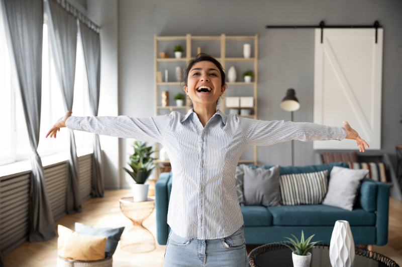 Overjoyed young indian woman outstretched arms in sides