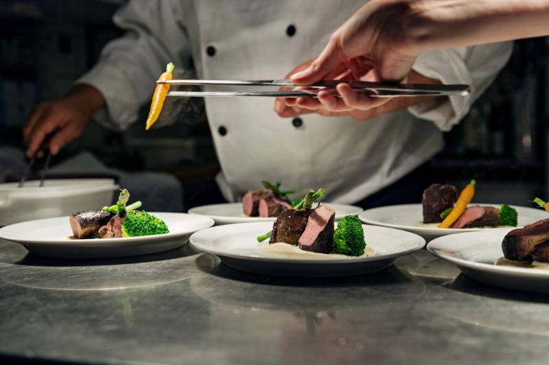 Professional Chef at work in a busy kitchen getting ready for service